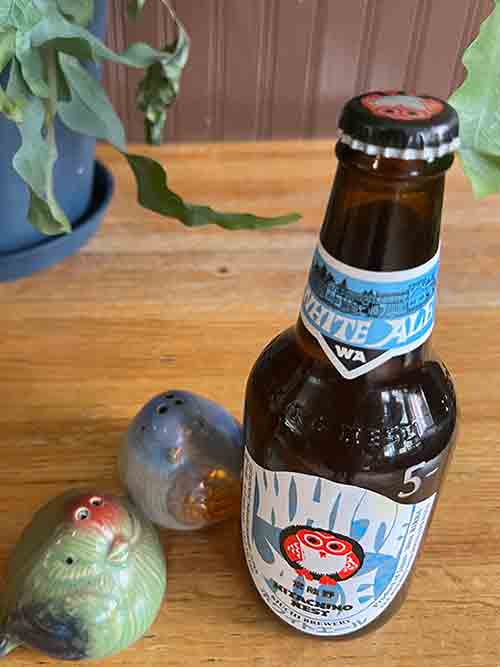Bottle of beer next to salt and pepper shakers